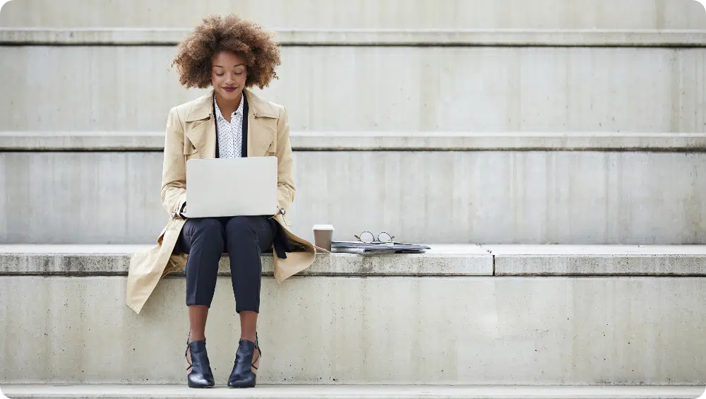 Five benefits of a client portal. Woman sitting with a laptop on her laps.