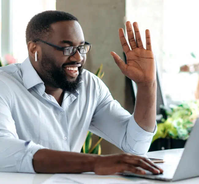 man on a video call waving to colleague