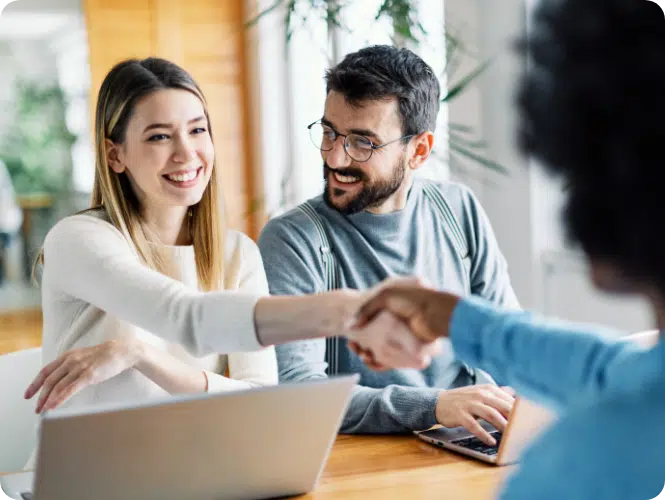 Strengthen client relationships. Colleagues shaking hand over the desk.