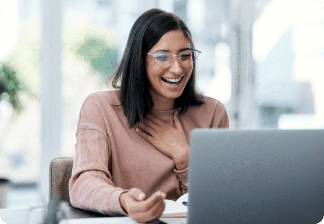 woman laughing at her laptop