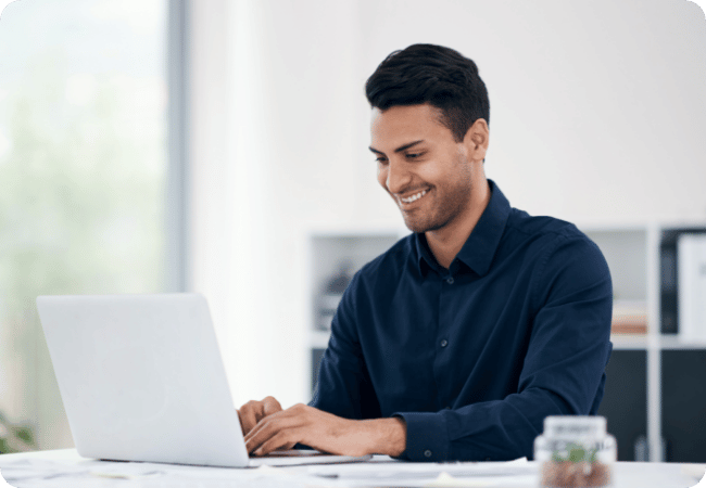 man smiling at his laptop