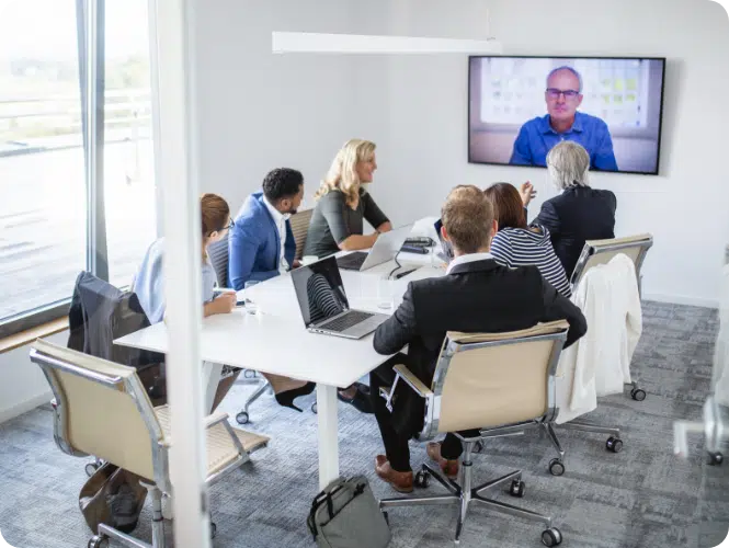 in-office board meeting with remote colleague on large screen