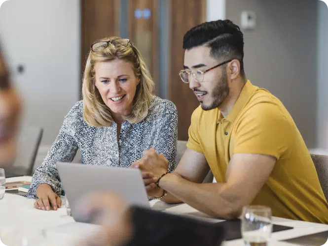 Man and woman working together at a laptop. Acquiring an advisory business