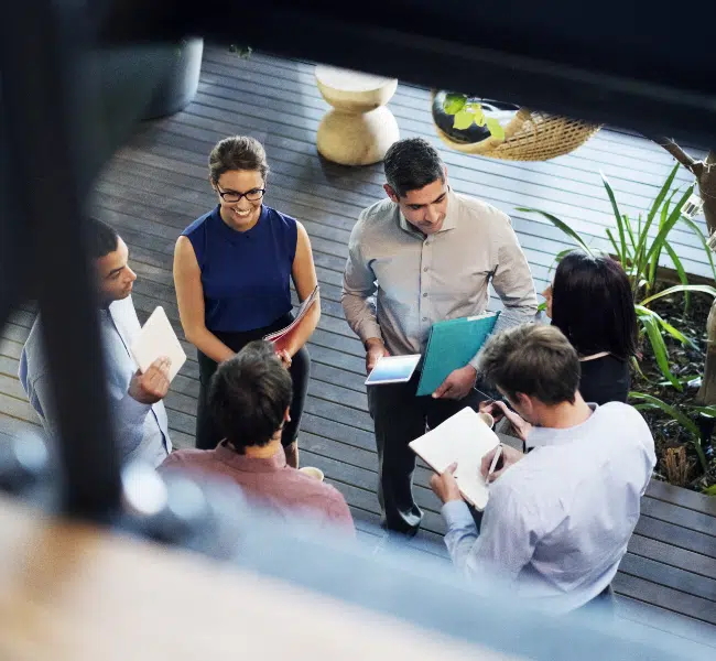 colleagues standing in a group talking and smiling - taken from above