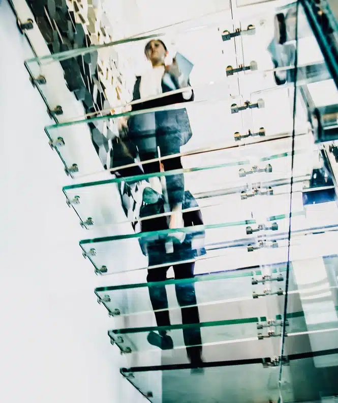 Motion blur of people walking on transparent glass spiral staircase in futuristic building on a contemporary office